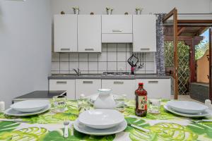 a kitchen with a table with plates and glasses at Villetta Vespucci in Agrustos +5 photos