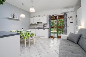 a kitchen and living room with a couch and a table at Villetta Vespucci in Agrustos
