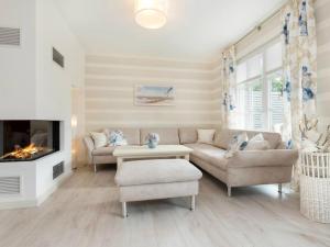 a living room with a couch and a fireplace at Ferienhäuser Zingster Perlen in Zingst