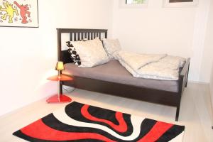 a bedroom with a bed with a red and black rug at Fewo im Herzen von Unterfranken in Marktbreit