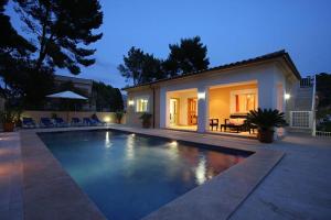 a swimming pool in front of a house at Can Medina in Pollença