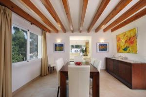 a dining room with white walls and a wooden ceiling at Can Medina in Pollença