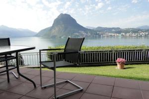 un patio con tavolo, sedie e vista sulle montagne di Panorama Studio Apartment a Castagnola
