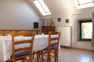 a dining room with a table and chairs and skylights at Gîte L'air pur in Roisin