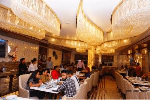 a group of people sitting at tables in a restaurant at Hotel Imperial Blu in Similigurha