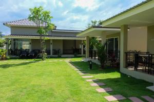 The Oasis Khaolak Resort - SHA Plus في خاو لاك: منزل أمامه حديقة