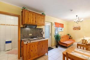 a kitchen with wooden cabinets and an orange couch at Villa am Keltenberg - El Sol in Glauburg