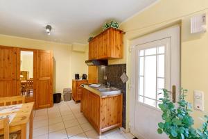 a kitchen with wooden cabinets and a sink at Villa am Keltenberg - El Sol in Glauburg +14 photos