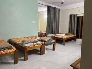 a room with three beds with pillows on them at Artham The River View in Gokarna