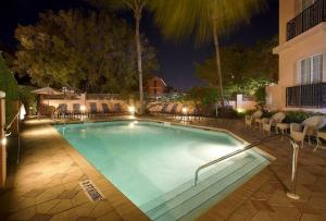 a swimming pool at night with chairs and a building at The Capri Inn in Naples