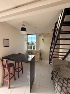 a dining room with a black table and chairs at Loft Luiz Gonzaga in Campina Grande