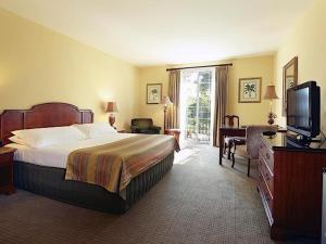 a hotel room with a bed and a television at The Capri Inn in Naples