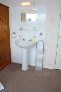 un bagno con un lavandino bianco e uno specchio di Beckside Guest House Keswick a Keswick