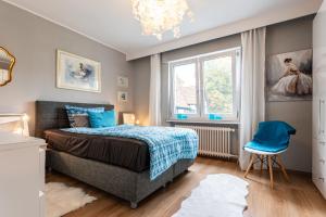 a bedroom with a bed and a window and a chair at Ferienwohnungen Lemma in Möhnesee