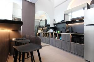 a kitchen with two bar stools and a counter at ST Signature Bugis Beach in Singapore