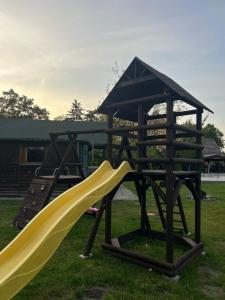 a playground with a yellow slide and a slideintend at Domek Wilamów in Wilamów