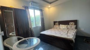 a bedroom with a bed and a chair and a window at Vijay Laxmi Farm House in Manjhāoli