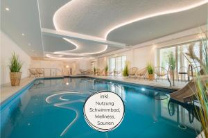 a swimming pool in a hotel with a sign that guaranteed wellness at Ferienhaus II Wiesenblick in Grömitz