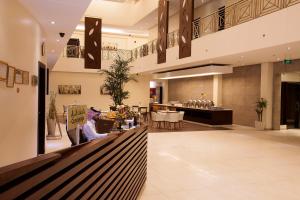 a lobby of a restaurant with a person sitting at a counter at Grand Lily Hotel Suites in Al Hofuf
