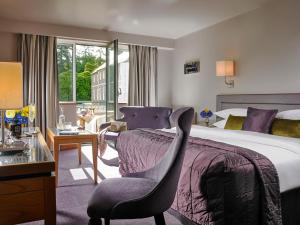 a hotel room with a bed, chair, and desk at Maryborough Hotel & Spa in Cork