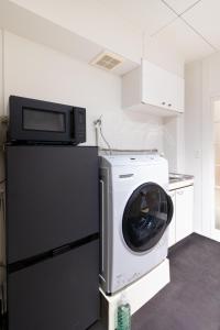 a washer and dryer sitting on top of a refrigerator at Epilogue Hotel 202 in Fukuoka