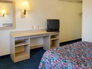 a room with a desk with a tv and a bed at Loyalty Inn in Brice