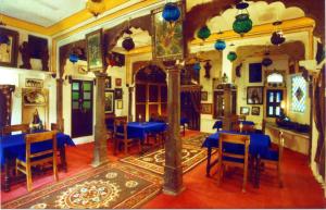a dining room with blue tables and blue chairs at Haveli Braj Bhushanjee Heritage Hotel and Museum in Būndi