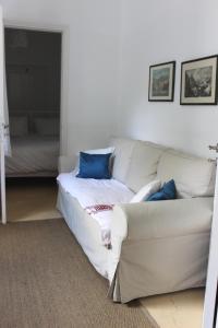 a living room with a white couch and blue pillows at Studio Annezo in Hydra