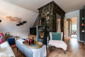 a living room with a couch and a stone fireplace at Ferienwohnungen Lemma in Möhnesee