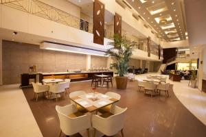 ein Restaurant mit Tischen und Stühlen in einem Gebäude in der Unterkunft Grand Lily Hotel Suites in Al Hofuf