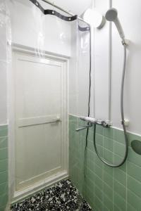 a shower with a glass door in a green tiled bathroom at Epilogue Hotel 202 in Fukuoka
