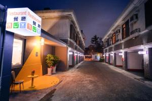 una calle vacía por la noche con un cartel en un edificio en Guest Motel-Zhubei, en Zhubei