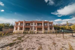 a large house in the middle of a field at Indus County in She