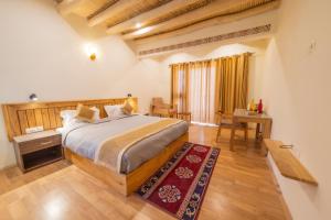 a bedroom with a large bed and a wooden floor at Indus County in She