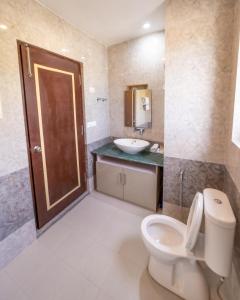 a bathroom with a toilet and a sink at Indus County in She