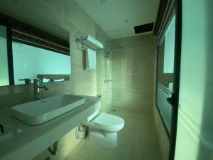 a bathroom with a white toilet and a sink at A3villa Hotel in Thạch Cầu