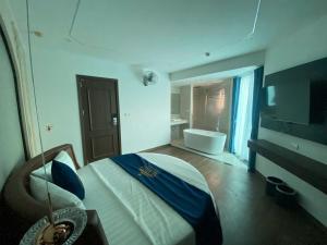 a bedroom with a bed and a bathroom with a tub at A3villa Hotel in Thạch Cầu