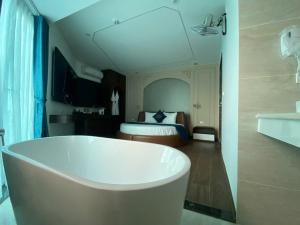 a bathroom with a tub and a bedroom with a bed at A3villa Hotel in Thạch Cầu