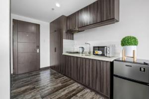 a kitchen with wooden cabinets and a refrigerator at Espacio Hotel in Manila