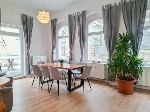 a dining room with a table and chairs and windows at Haus Felsenpost in Stadt Wehlen