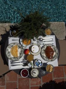 a table with plates of food on it next to a pool at Relais Conac 1888 - Luxury B&B - Adults Only in Castelnuovo Don Bosco