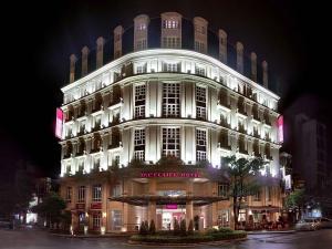 a large white building with lights on it at night at Mercure Hanoi La Gare Hotel in Hanoi