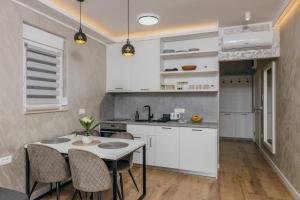 a kitchen with white cabinets and a table and chairs at Apartments Via Mare in Petrovac na Moru +49 photos