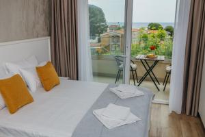a bedroom with a bed and a balcony with a table at Apartments Via Mare in Petrovac na Moru