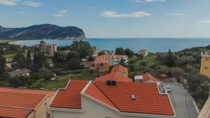 a view of a town with red roofs and the ocean at Apartments Via Mare in Petrovac na Moru