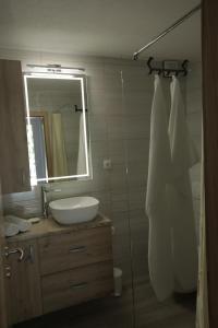 a bathroom with a sink and a mirror at Apartman BARONI in Pinezici