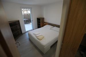 a bedroom with a bed with two towels on it at Apartman BARONI in Pinezici
