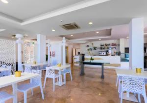 a restaurant with white tables and white chairs at Miami Suite in Bellaria-Igea Marina
