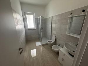 a bathroom with a toilet and a sink and a shower at La Marina Rooms HOWME in Torre a Mare +4 photos
