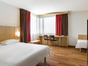 a hotel room with a bed and a desk at ibis Warszawa West Station in Warsaw +89 photos